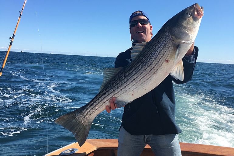 Erik Peterson with cow striped bass enjoys East End summer adventures