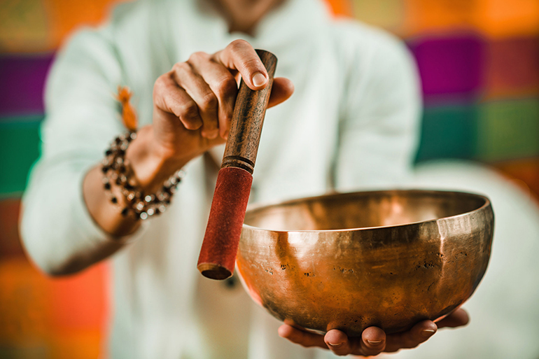 therapist using tibetan singing bowl in sound therapy