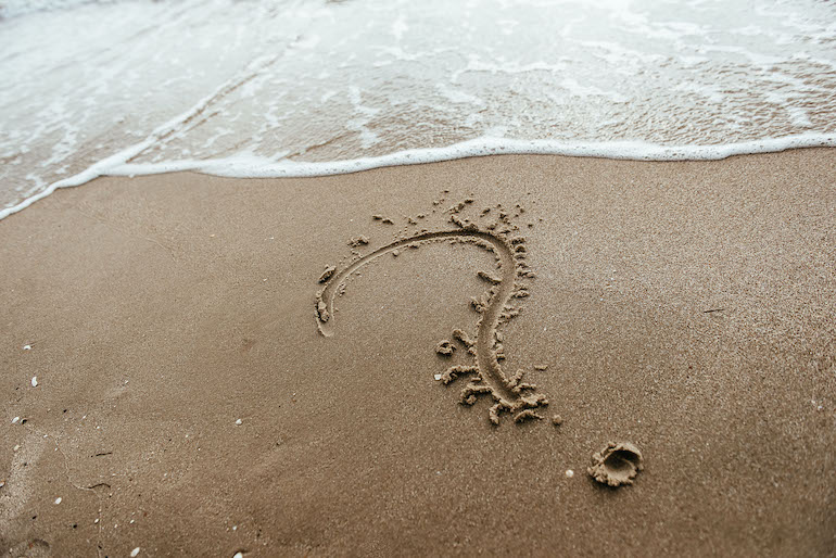 question mark sign in sand beach