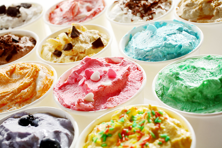 Display of tasty summer ice cream in different flavors and colors served in individual tubs viewed obliquely for advertising for a parlour or ice cream shop