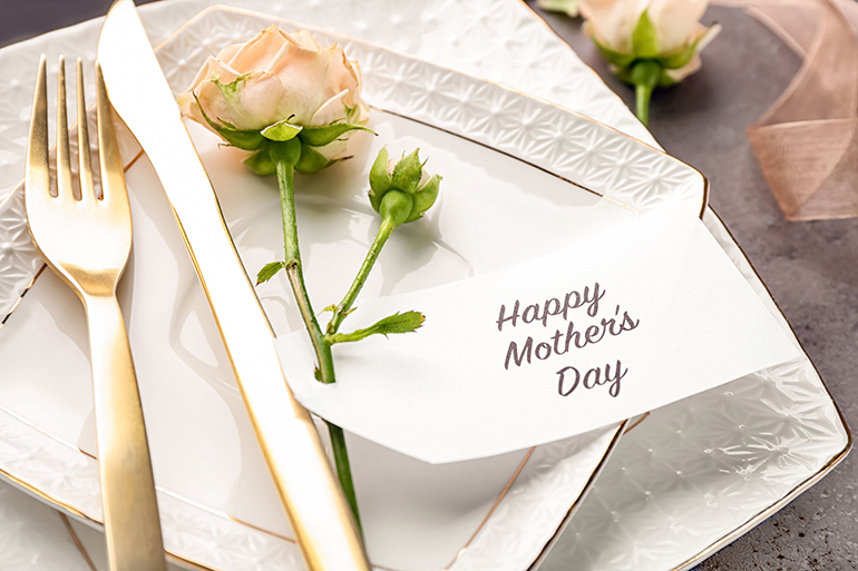 Elegant table layout for dinner with flowers and greeting card