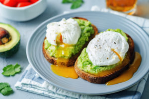 Poached egg Avocado Rye Toasts on a stone background. toning. selective focus
