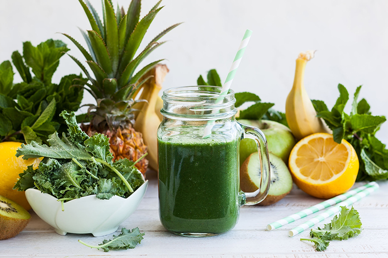 Fresh kale fruit smoothie in a jar with ingredients