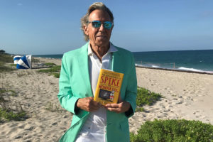 Bill Boggs holding Spike the Wonder Dog book on Hamptons beach