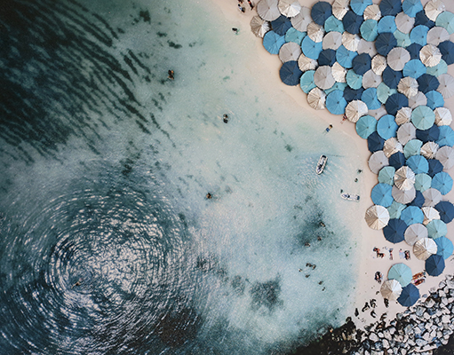 One of the many canvas prints with resin, crushed glass and miniature umbrellas in Denis Leon's Wear Sunscreen series