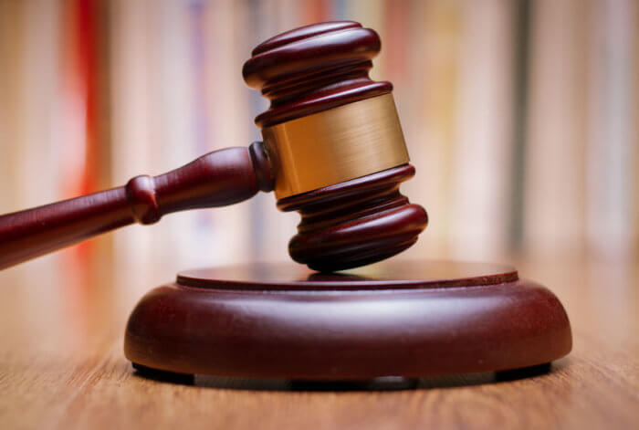 Close up Shiny Wooden Law Gavel in Dark Brown Color, on Top of Wooden Table at the Office.