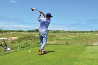 Man hitting golf ball at Maidstone Club in the Hamptons