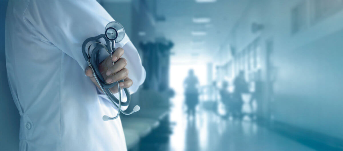 Doctor with stethoscope in hand on hospital background