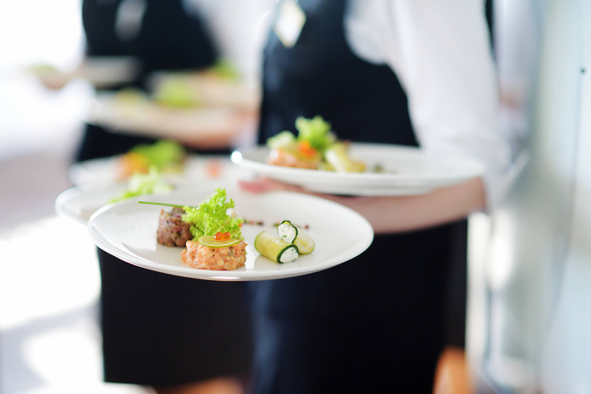 Waiter carrying plates with meat dish