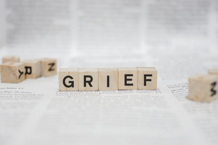 Grief Word Written In Wooden Cube - Newspaper