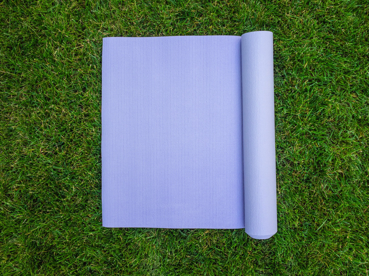 Purple yoga Mat on the grass. Mat for yoga, Pilates or fitness