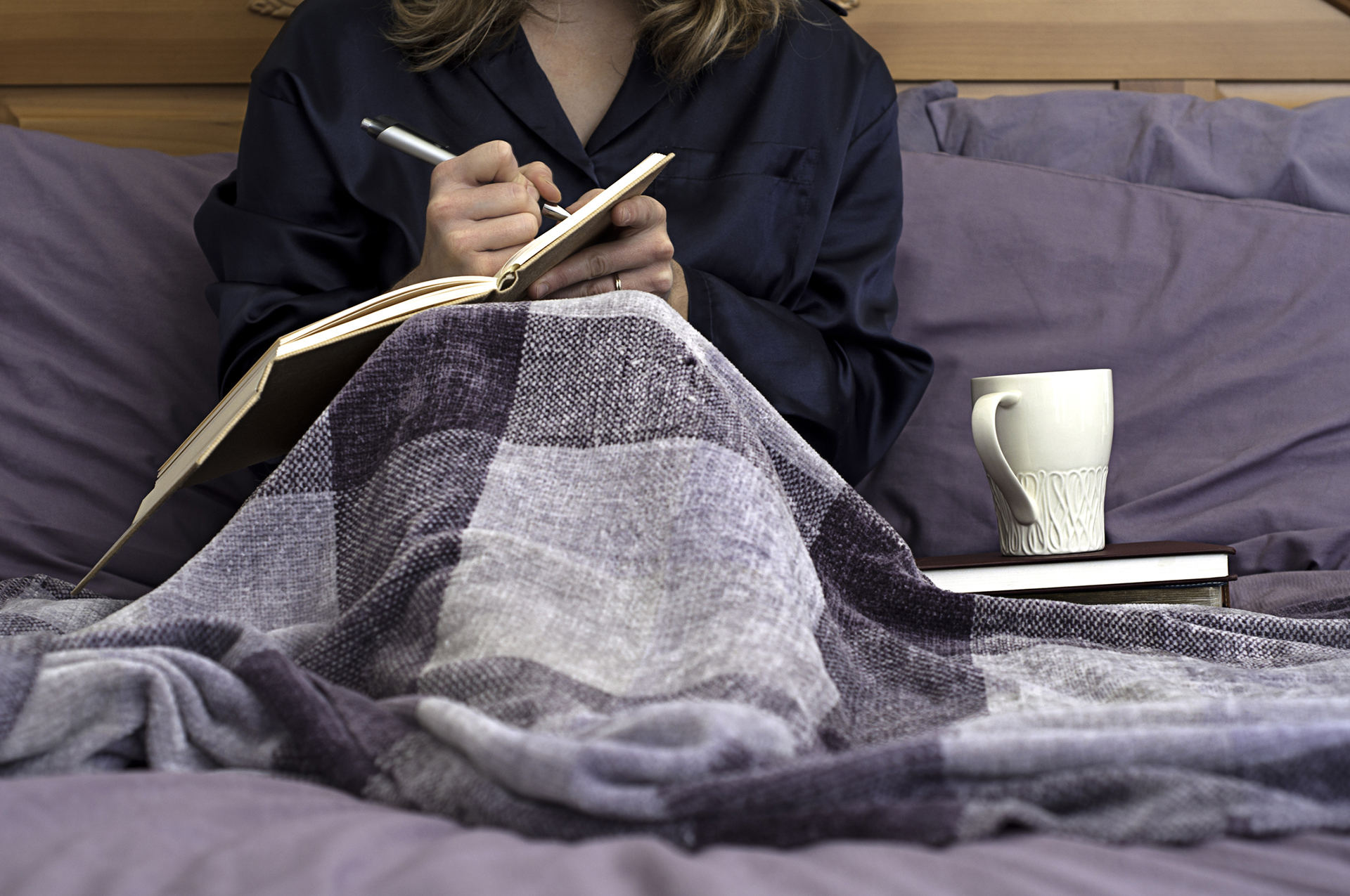 Woman journaling in bed