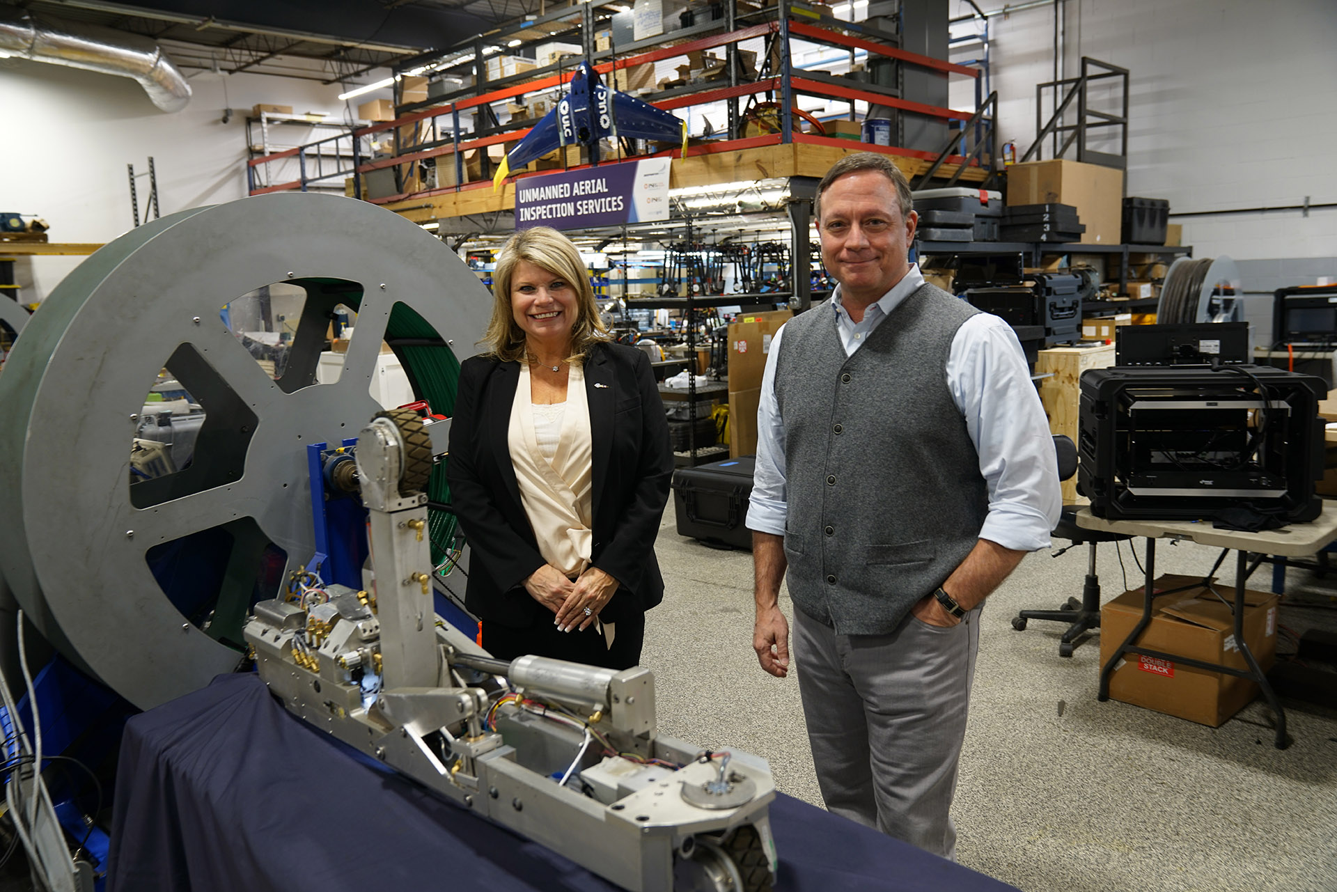 Jodi Giglio standing next to Greg Penza, founder and CEO of ULC Robotics, and a CISBOT robot.