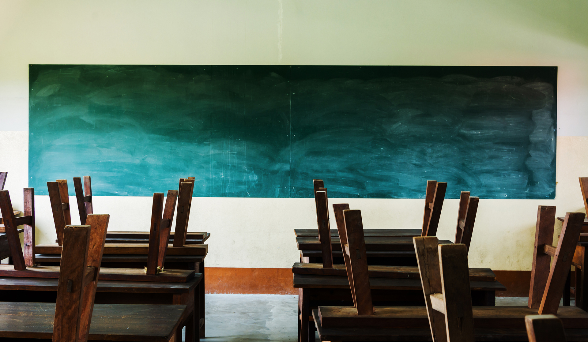 chair and table in class room with black board background, no student, school closed concept