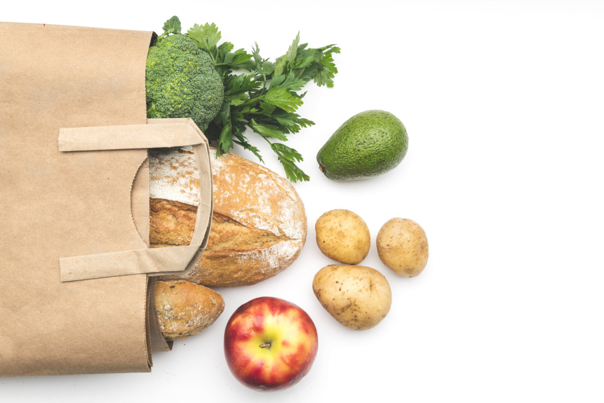 Full paper bag of different health food on white