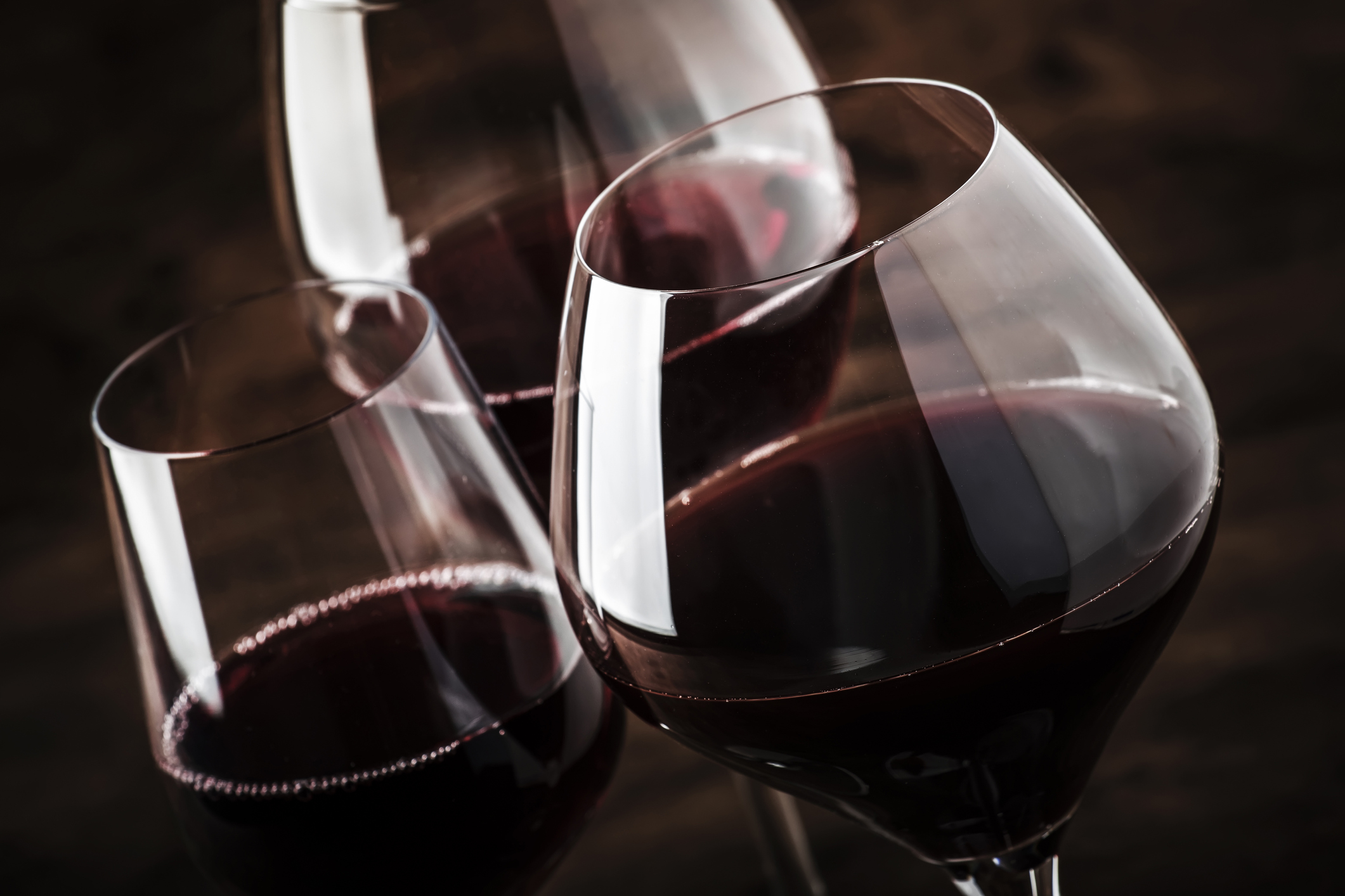 Selection of red wine on wine tasting. Dry, semi-dry, sweet red wines in special wine glasses on old wooden table background. Copy space