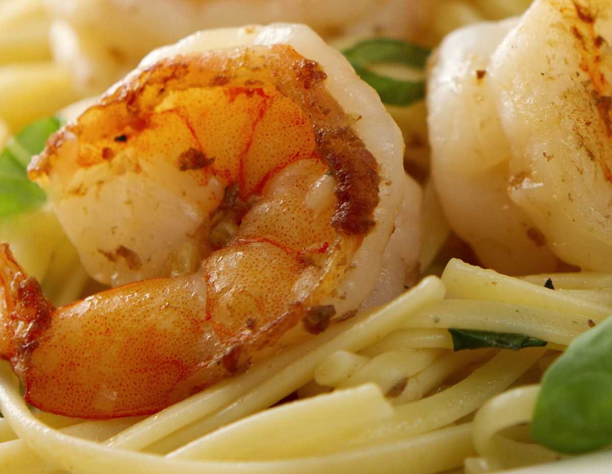 Jumbo shrimp scampi and linguini with basil on white plate