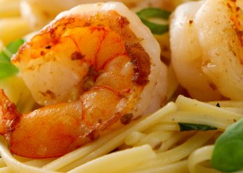 Jumbo shrimp scampi and linguini with basil on white plate