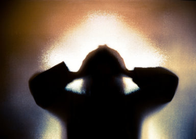 Silhouette of depressed abused woman with hands on head