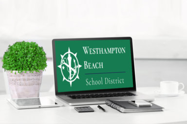 Modern workplace with laptop on table indoors. Westhampton Beach School District on screen