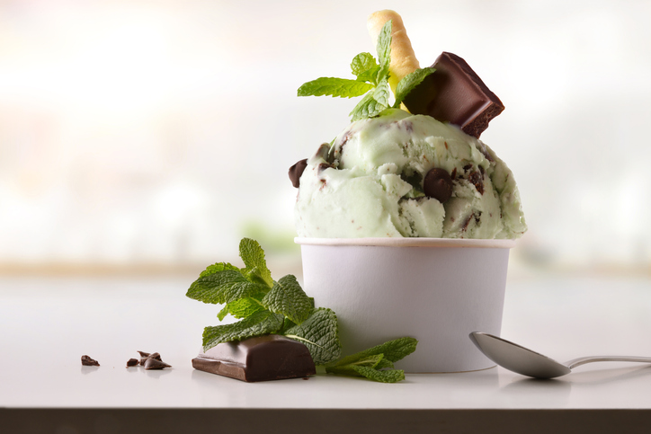Mint choco ice cream cup on white table homemade with kitchen background. Horizontal composition. Front view.