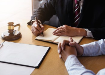Close up of gavel, Male lawyer or judge Consult with client and working with Law books, report the case on table in modern office, Law and justice concept