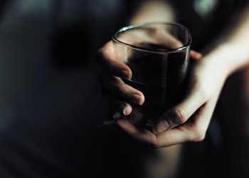 woman's hand with alcohol drink in glass with copy space