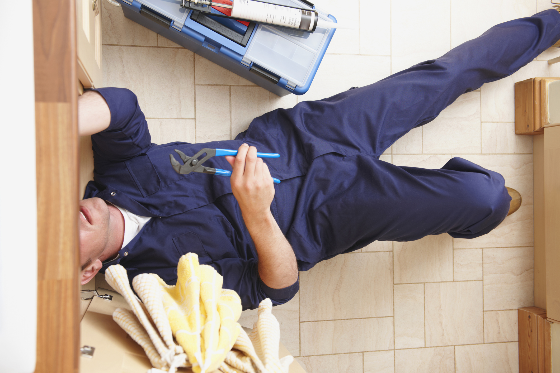 Overhead view of Caucasian plumber repairing sink