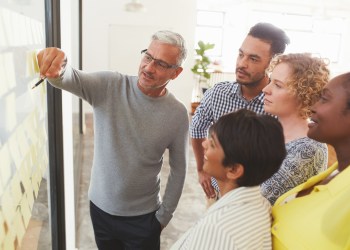 Diverse businesspeople brainstorming with adhesive notes in a meeting