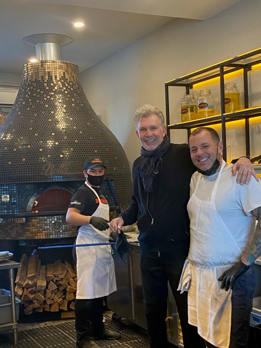 Michael Brunetti with his team in front of his wood-burning oven, imported from Naples.