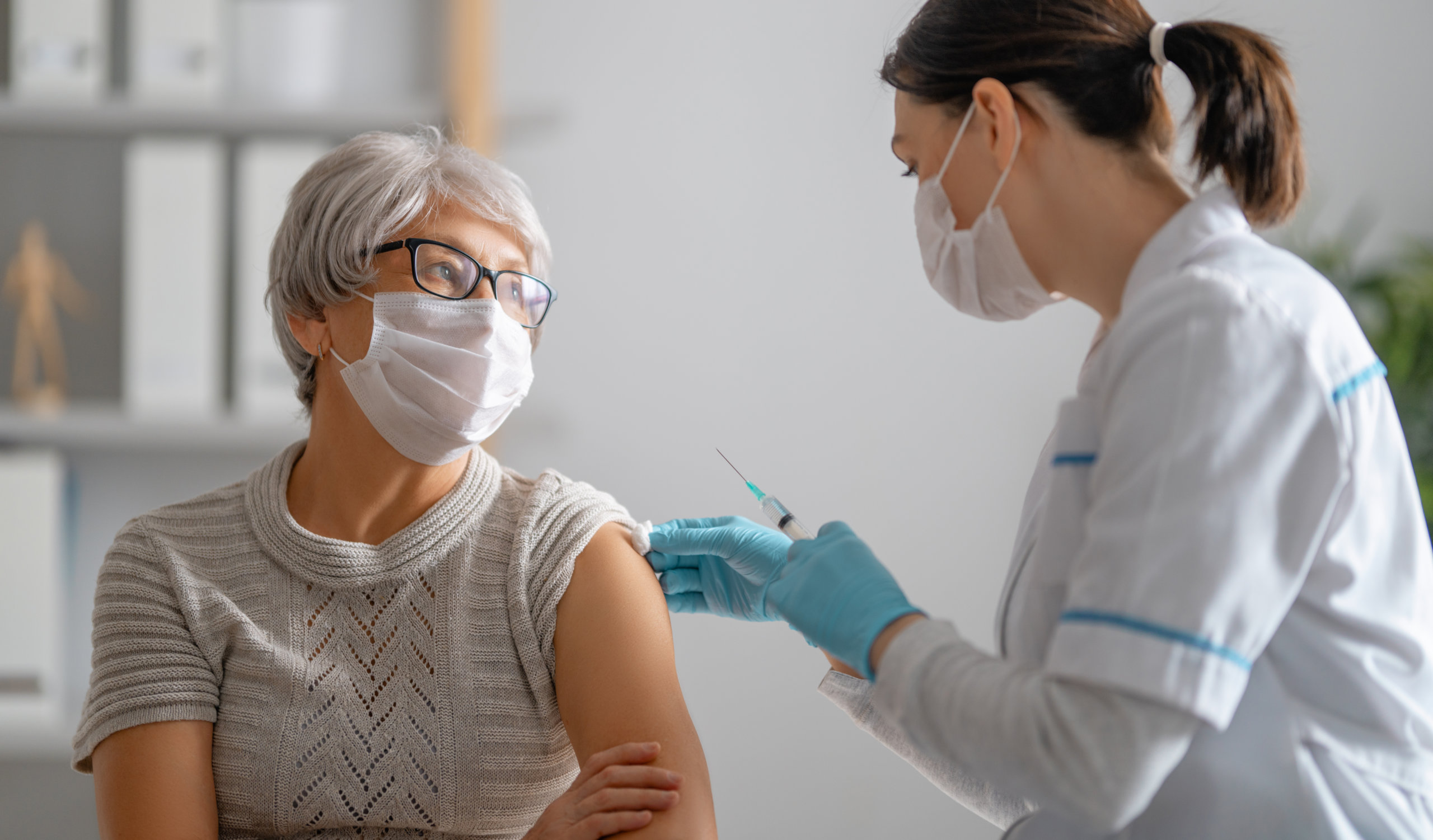 Doctor giving a senior woman a vaccination. Virus protection. COVID-2019.