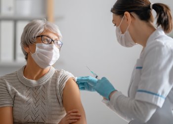 Doctor giving a senior woman a vaccination. Virus protection. COVID-2019.