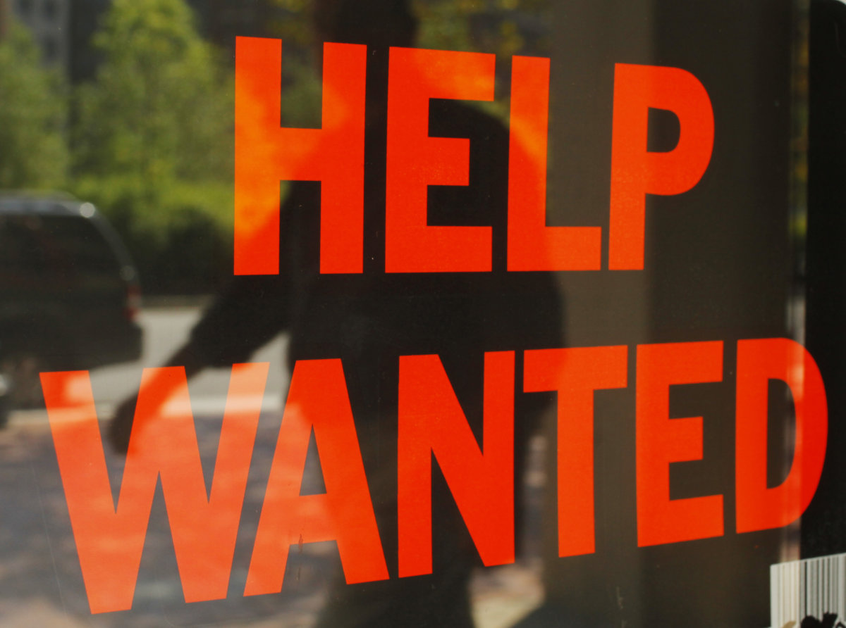 A “Help Wanted” sign in the window advertises a job opening at a dry cleaners in Boston