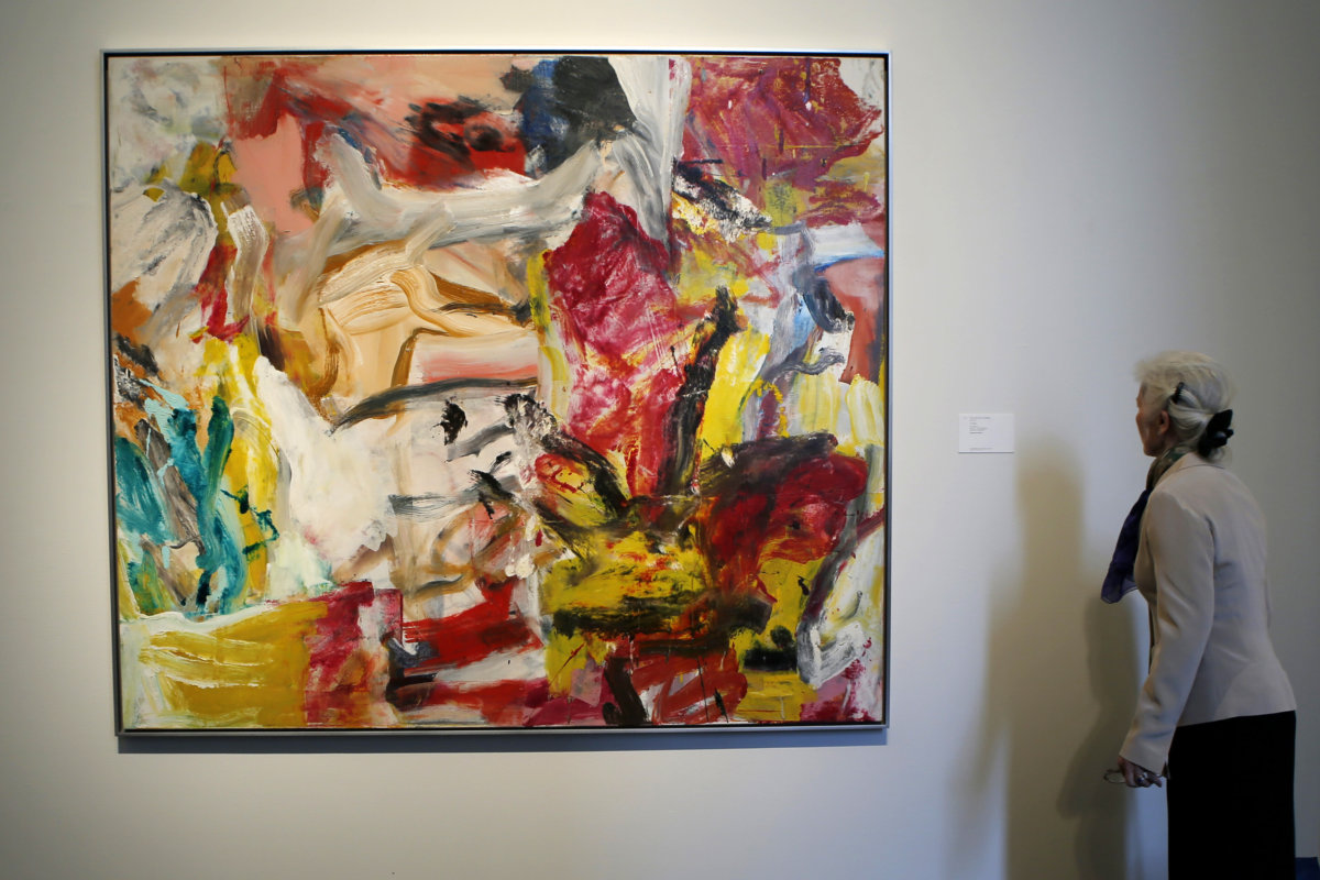 A woman checks “Untitled” by Willem De Kooning during a preview of Sotheby’s impressionist and modern art evening sale in New York