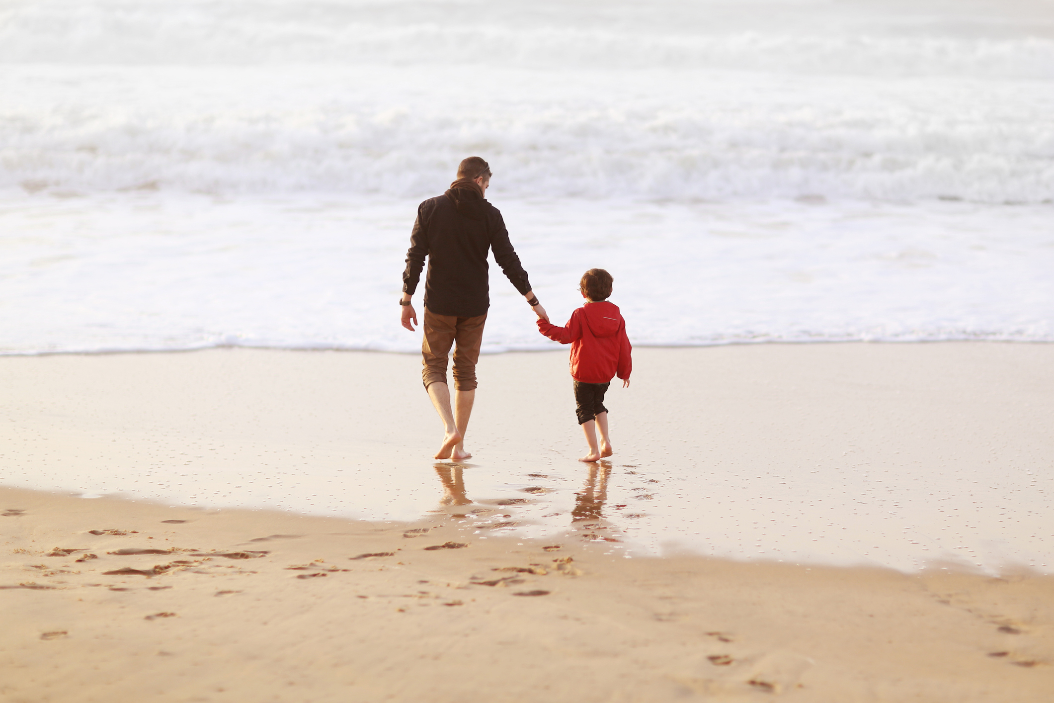 A 5 years old boy and his dad on the beach