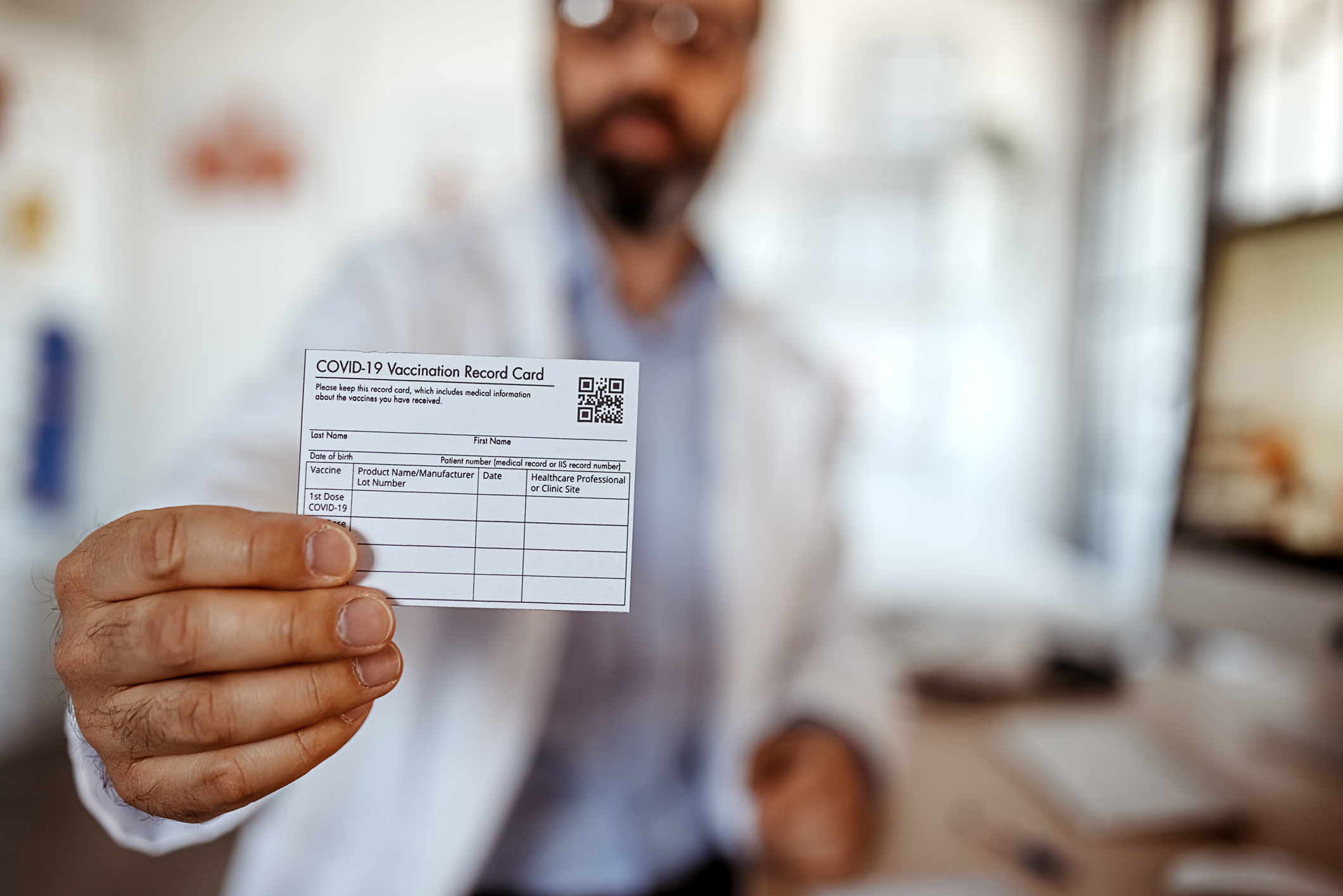 Doctor showing vaccine card at vaccination site