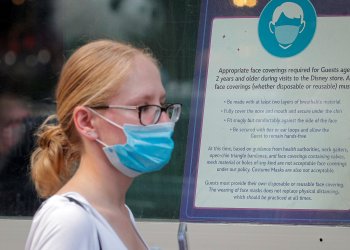 A woman wears a mask against COVID-19, following the CDC recommendation to protect against the Delta variant
