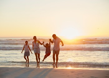 Parents with children enjoying vacation on beach