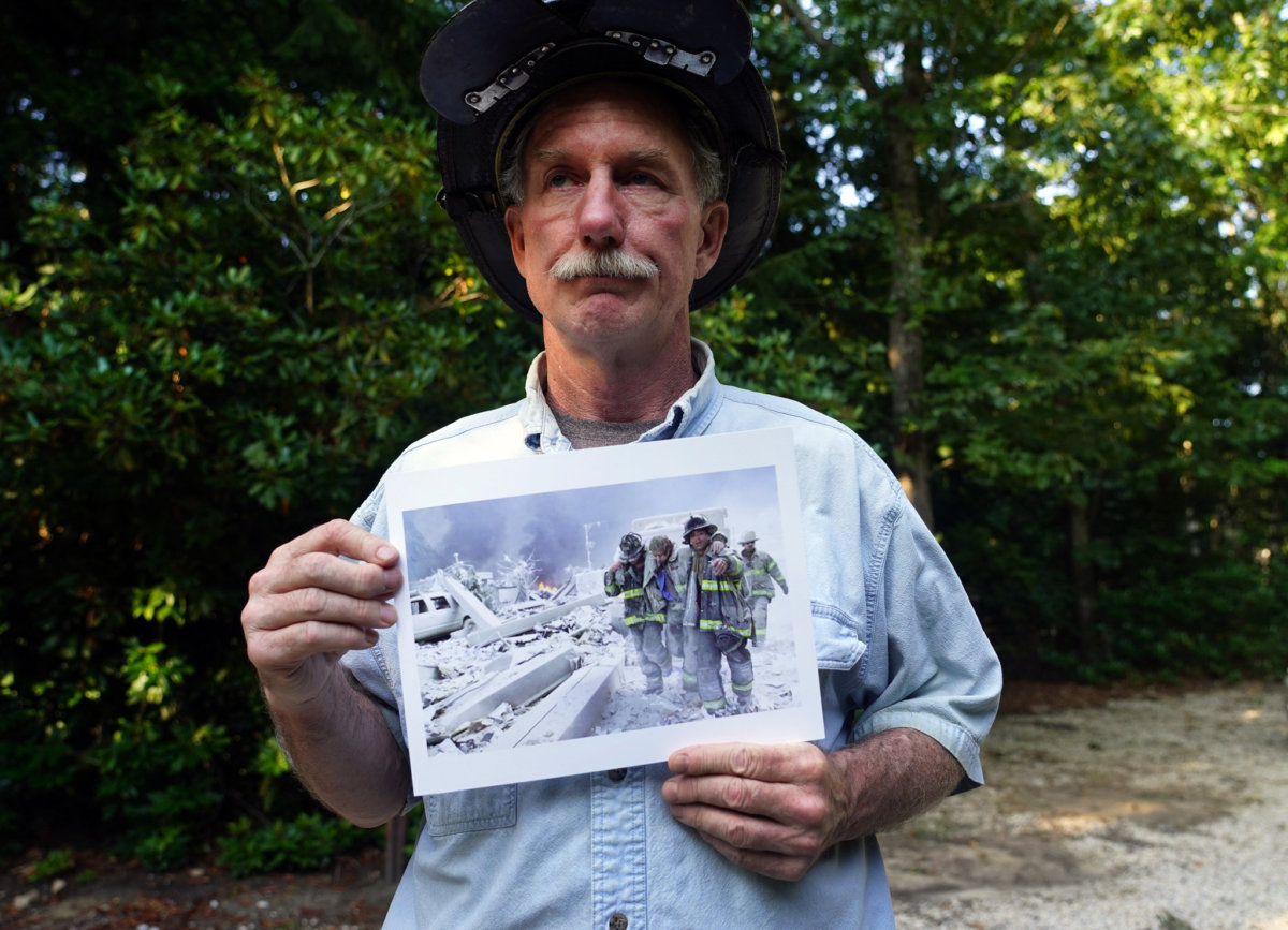FDNY Lt. Raymond Brown, August 29, 2021 in Sag Harbor, N.Y. Approaching the 20th anniversary of Sept. 11 he holds a photograph of himself, center, taken by New York Daily News photographer Todd Maisel and recalls how he survived the terrorist attack at the World Trade Center. (Photo by Debbie Egan-Chin)