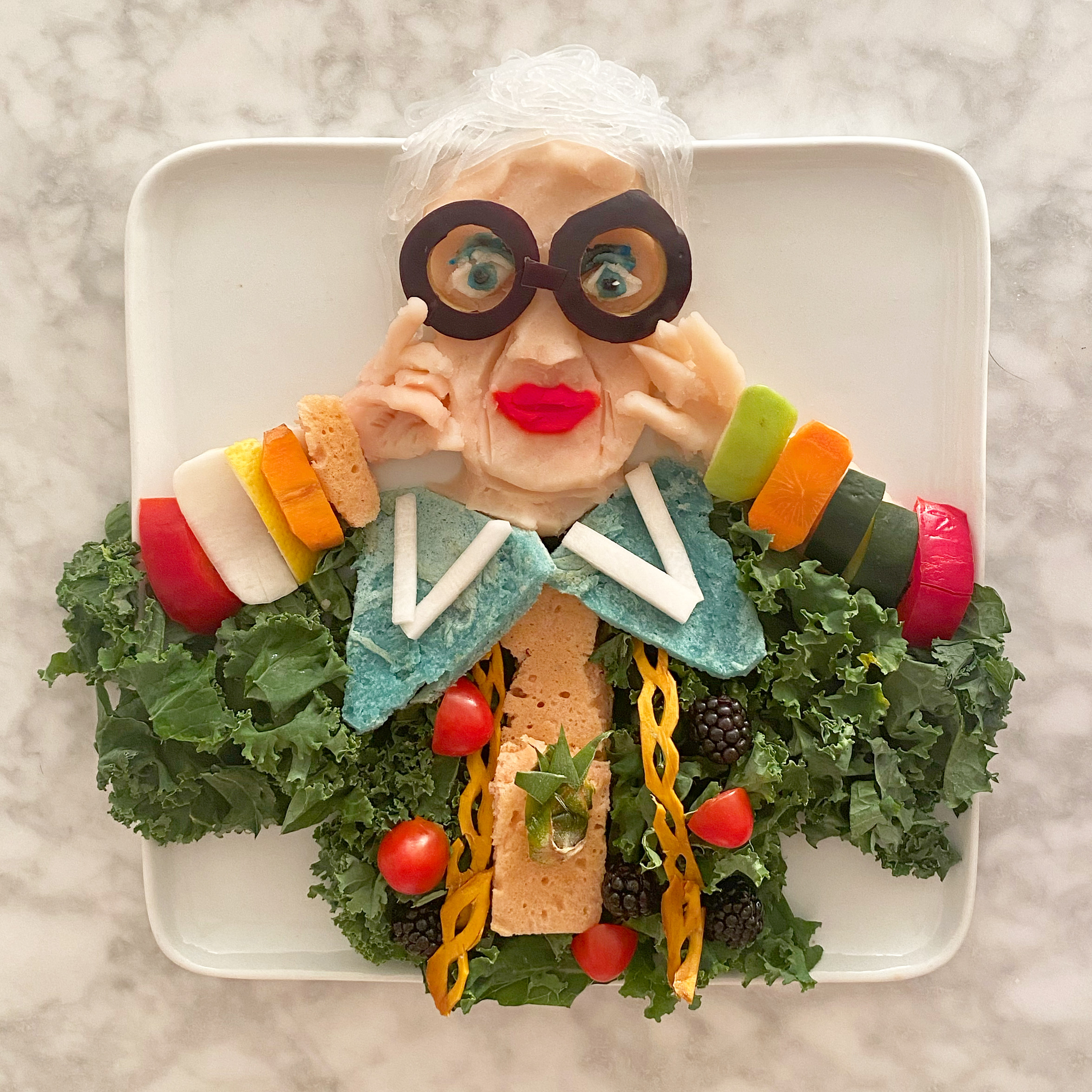Iris Apfel – mashed potatoes, kale, dried mango, red pepper, cherry tomatoes, blackberries, turnip, rice noodles, dyed pancake, cucumber, carrot, apple, and pineapple by Harley Langberg