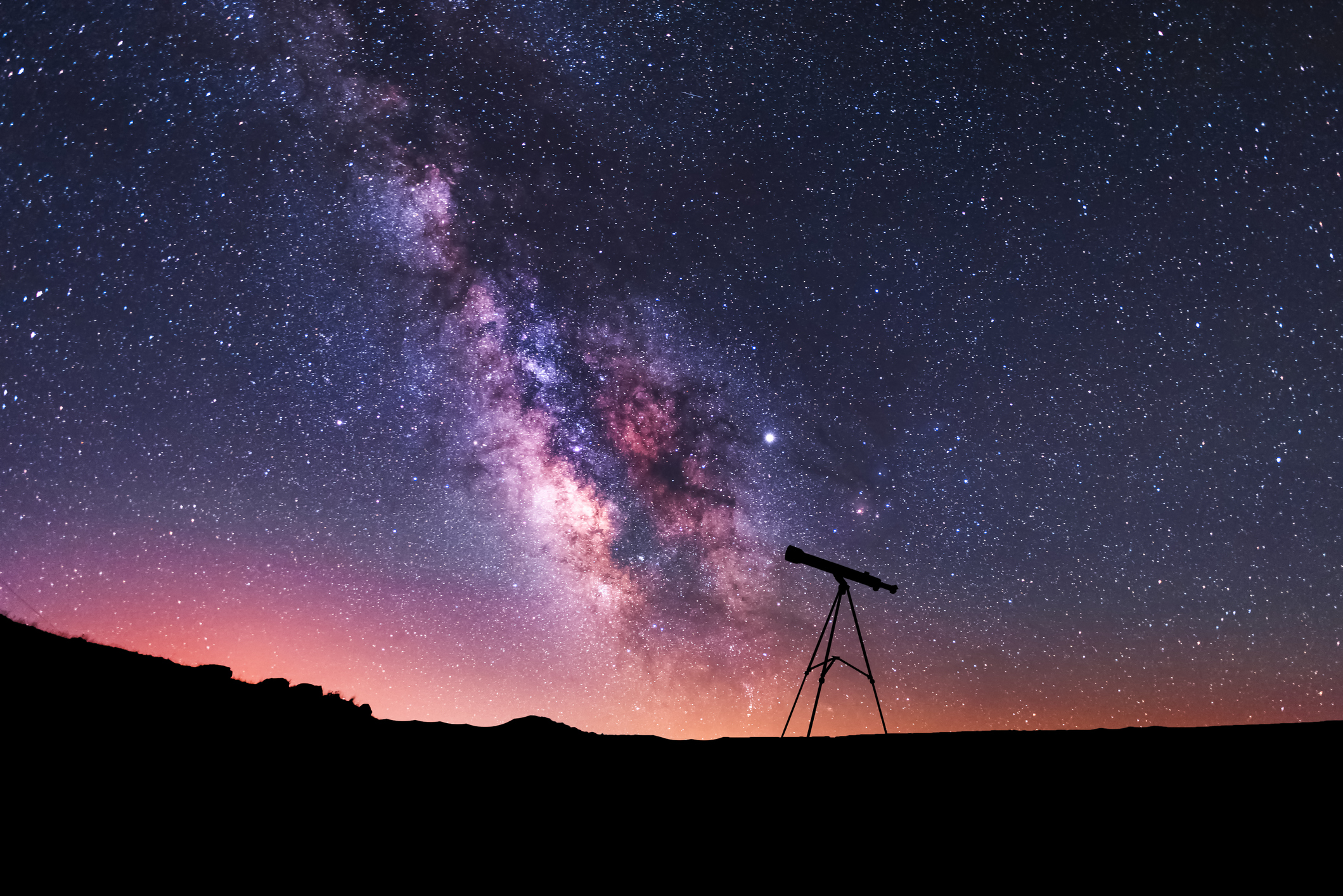 Silhouette of a telescope at the starry night and bright milky way galaxy.