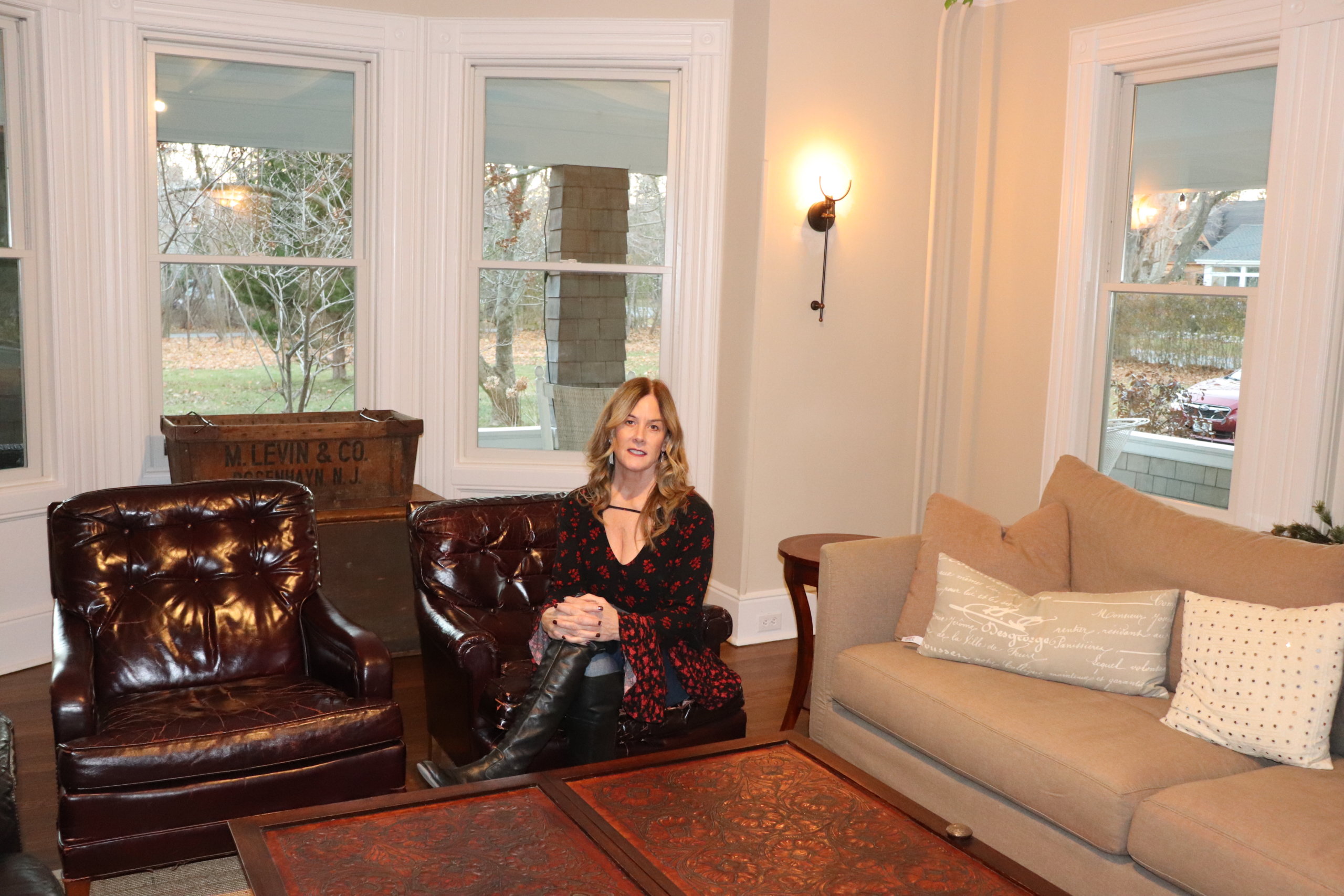 Tracy Sutton sits inside the Inn at Orient parlor with newly installed windows and furniture