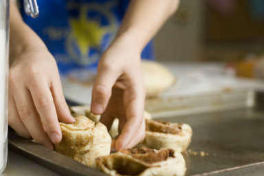 Kid Baking Cinnamon Rolls Homemade; focus on hands.