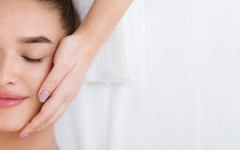 Woman getting professional facial massage, top view, copy space