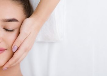 Woman getting professional facial massage, top view, copy space