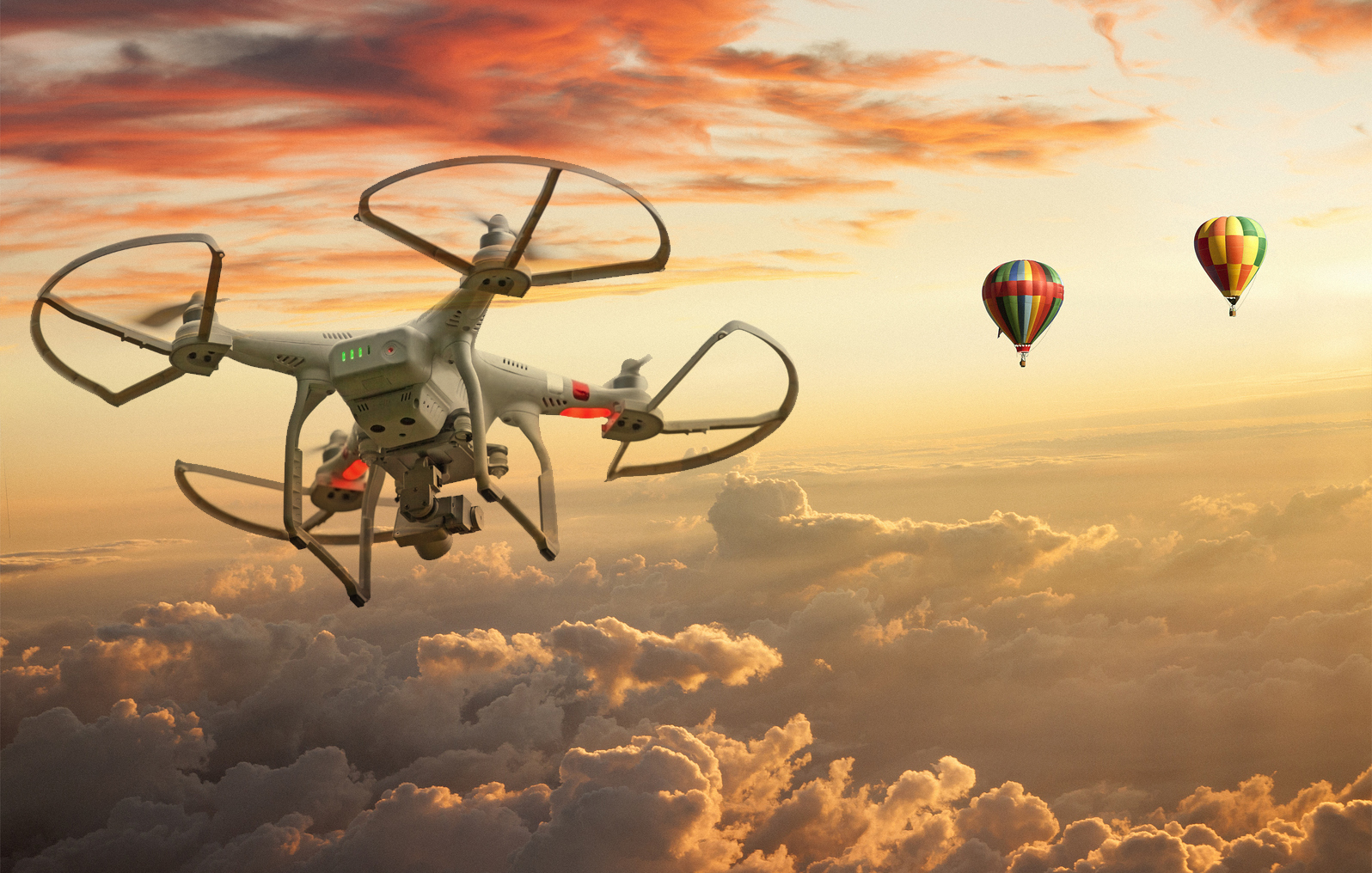 Two Hot air balloons and a drone floating over clouds at sunset