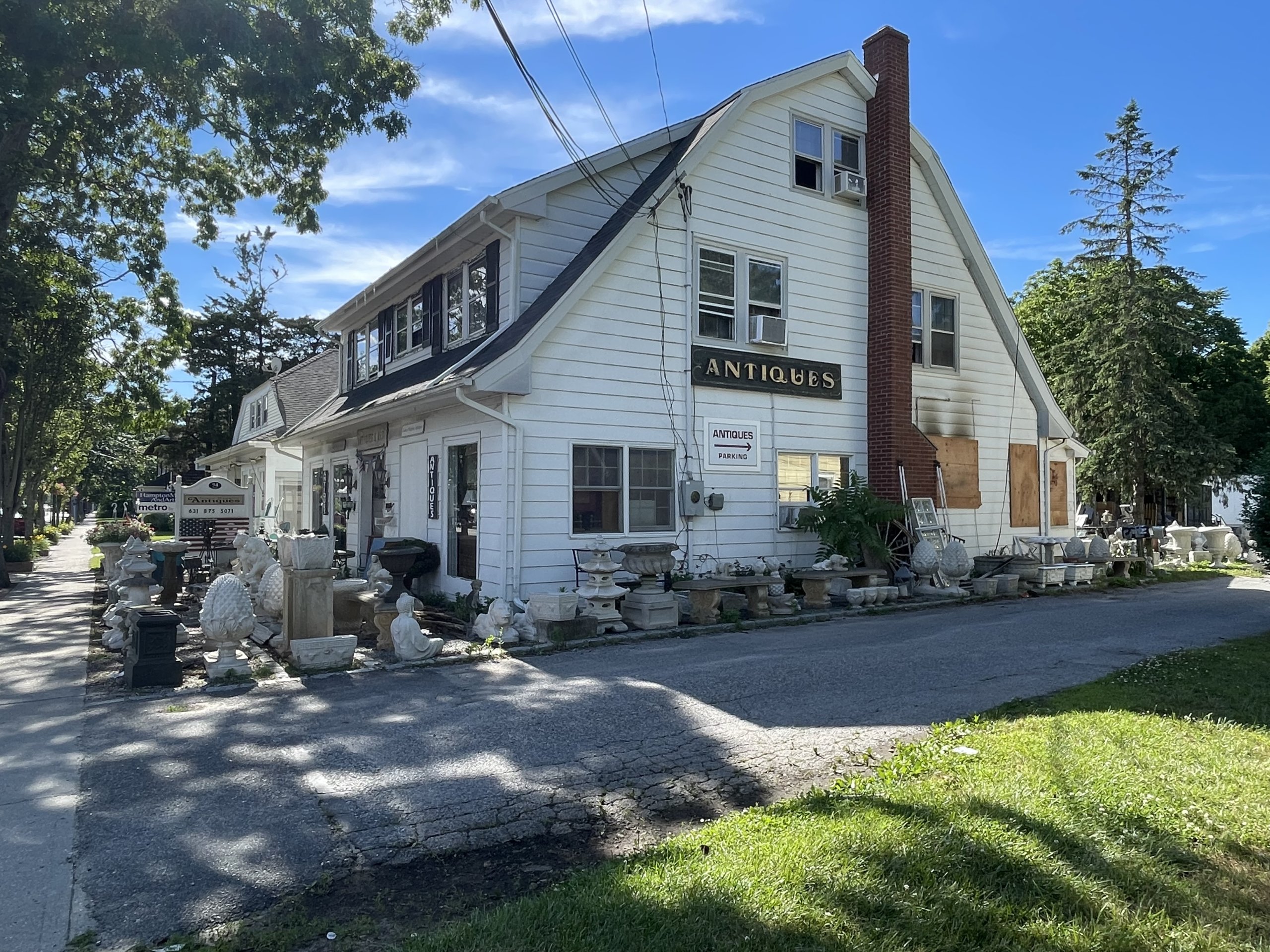 Windows were boarded up after the fire at James Maguire Antiques in Hampton Bays