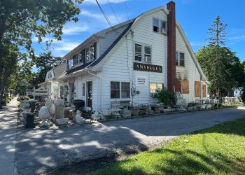 Windows were boarded up after the fire at James Maguire Antiques in Hampton Bays