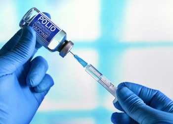 Vaccination for booster shot for Polio IPV Inactivated poliomyelitis Virus in the child population. Doctor with vial of the doses vaccine and syringe for Polio IPV Inactivated poliomyelitis Virus polio vaccine