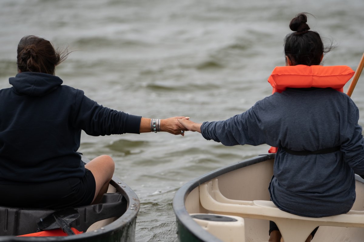 A mother and daughter hold hands at the start of the 2021 annual Shinnecock Whalers Mishoon Race